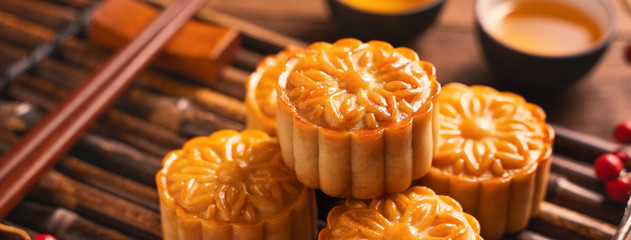 Moon cake Mooncake table setting - Round shaped Chinese traditional pastry with tea cups on wooden...