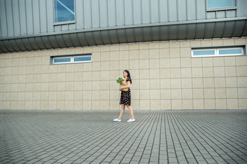 A girl with a paperbag near the supermarket. The concept of shopping, lifestyle.