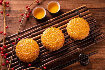 Moon cake Mooncake table setting - Round shaped Chinese traditional pastry with tea cups on wooden...