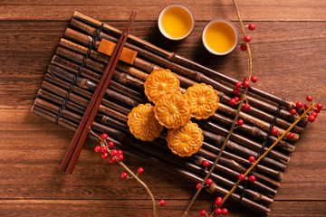 Moon cake Mooncake table setting - Chinese traditional pastry with tea cups on wooden background,...