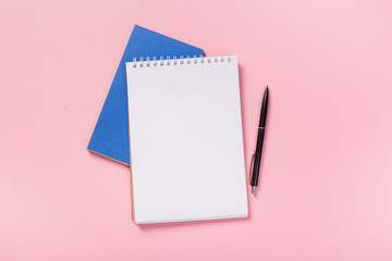 school notebook on a pink background, spiral notepad on a table.