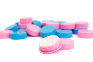 Pink and blue plastic cream jars on white background