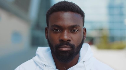 Portrait serious face african american man ooking at camera enjoying in urban city handsome confident lifestyle street urban attractive close up confidence outdoors close up slow motion. The best - Powered by Adobe