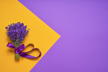 Bunch of fresh lavender on yellow-purple background. Violet flowers. Greeting floral card with place for text. Top view, copy space