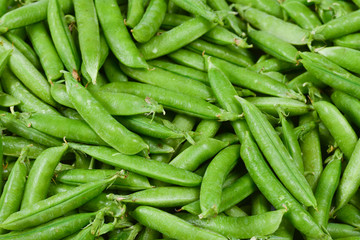 Fresh pea pods as background. Top view.