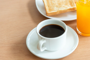 White coffee cup and toast on the table with green nature background