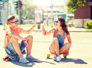 summer holidays, extreme sport, gesture and people concept - happy teenage couple with short modern...