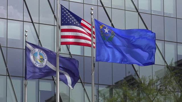 Waving flags of USA, Nevada state and Las Vegas city at the Las Vegas City Hall.