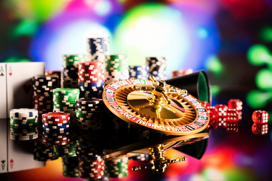 Casino concept. High contrast image of casino roulette, poker chips, dice. Bokeh background. 