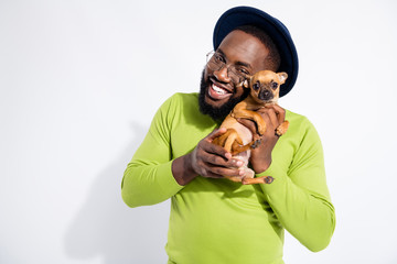 Portrait of cheerful guy hugging his toy terrier wearing eyeglasses eyewear isolated over white background