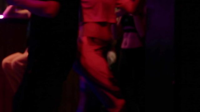 Couple dancing on a dance floor in the night club, close up, only hips in frame