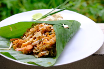 close up pad thai with shrimp in banana leaf