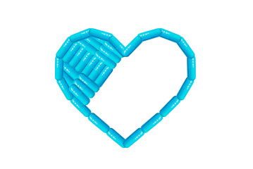 Heart shape made from blue pills and capsules isolated on white background