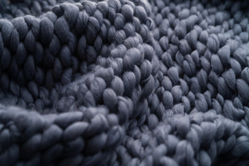 Merino wool handmade knitted large blanket, super chunky yarn, trendy concept. Close-up of knitted blanket, merino wool background. designer blanket made of beige smoky wool. - obrazy, fototapety, plakaty