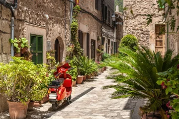 Fotobehang Steegje in Valldemossa met ingemaakte bloemen en rode scooter - Mallorca © Wolfgang Jargstorff