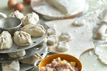 Uzbek national food manta, like dumplings, background of ingredients and semi-finished products