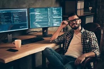 Fotobehang Portrait of nice attractive confident content cheerful bearded guy wearing checked shirt professional expert specialist shark genius at wooden industrial interior work place station indoors © deagreez