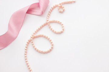mockup with pearls and pink ribbon on white background