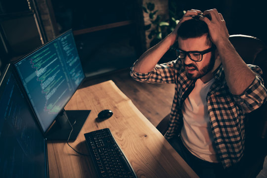 Close up photo handsome epic fail he him his guy crash code error system linux windows coder typing php css keyboard development outsource IT monitors table office wear specs formalwear plaid shirt