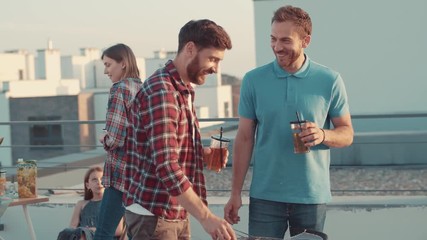 Exciting family barbecue in open area on summer evening. happy family eating snacks drinking juice and having good party time together.