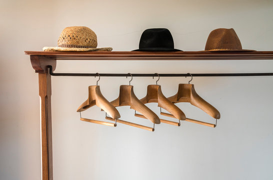 Un perchero antiguo a la entrada de una casa, con perchas y sombreros