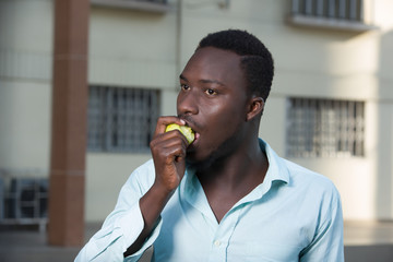 close-up of young man eating an apple.