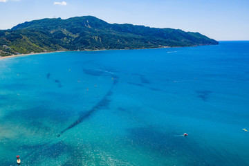 Aerial view of beautiful green and rocky island in the blue ocean.