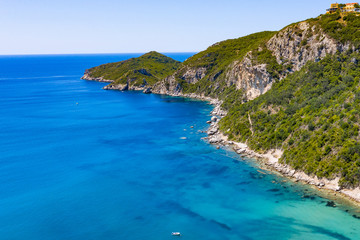 Aerial view of beautiful green and rocky island in the blue ocean.