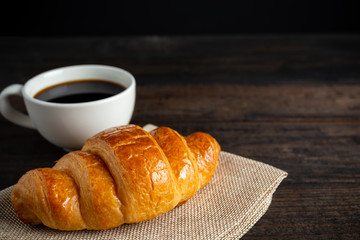 croissants and coffee on old wooden table.