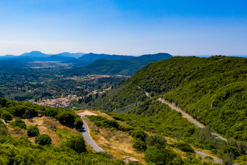 Fototapeta na wymiar Aerial view of road in high mountains among green trees.