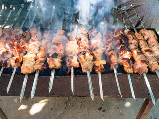 cooking many shish kebabs on brazier outdoors