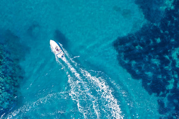 Aerial view of a white boat on turquoise sea water