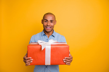 Portrait of charming guy hold hand gift 14-february 8-march feel content isolated over yellow background