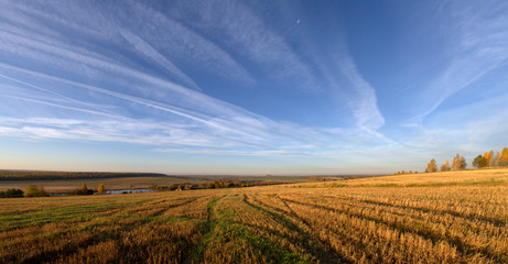 The sky is streaked with planes, and the field is streaked with tractors. Uvinsky district, Udmurt...