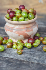 Fresh gooseberries in original bowls on wooden