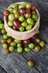 Fresh gooseberries in original bowls on wooden