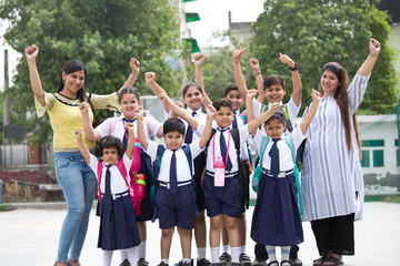Group of school children with teachers celebrating success