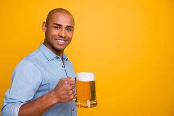 Photo of dark skin cool amazing guy hold hands beer glass let's celebrate face wear jeans denim shirt isolated yellow background