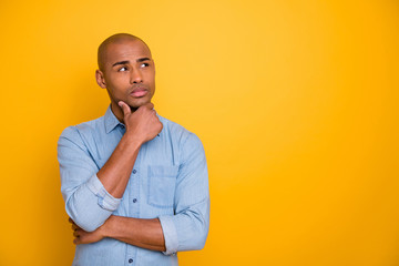 Photo of dark skin macho interested look up empty space hand touch chin wear jeans denim shirt...
