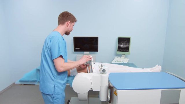Doctor prepares patient for kidney stone shockwave lithotripsy