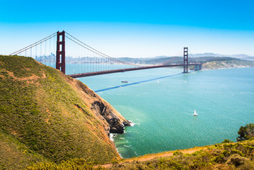 Golden Gate Bridge, California, U.S.A. Scenic city and landscape panorama over SF Bay waters, view from North Vista Point area,  with sailing boats and blue sky. Architectural icon of San Francisco