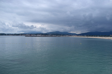 Panorámica de un mar y playa en un día nublado.