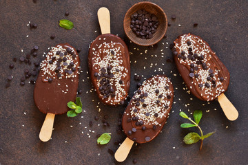 Ice cream with chocolate and sesame on a concrete background. Popsicle. View from above.