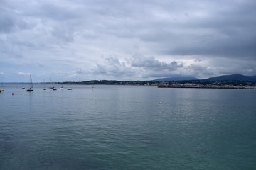 Panorámica de un mar y playa en un día nublado.