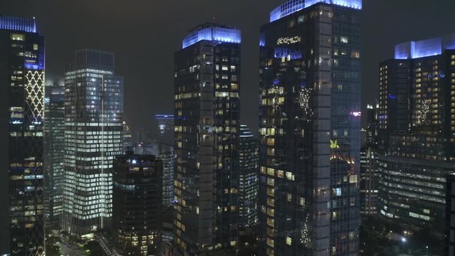 JAKARTA, Indonesia - July 17, 2019: Beautiful aerial landscape of skyscrapers and night lights in financial center. Shot in 4k resolution from a drone flying backwards