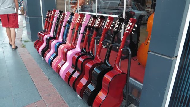 Street exhibition of guitars, trade showcase of musical instruments.