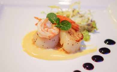 Grilled shrimp and scallop with mashed potato and vegetable salad on white plate
