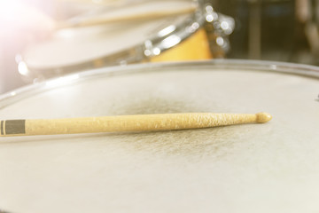 Drum stick and drum on black table background, top view, music concept