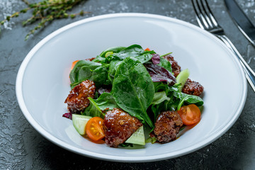 Salad with chicken liver on plate