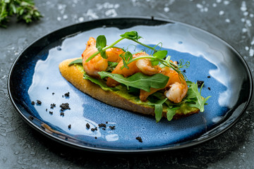 Bruschetta with prawns and guacamole on plate